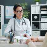 Médico conversa com paciente durante uma consulta em uma clínica.